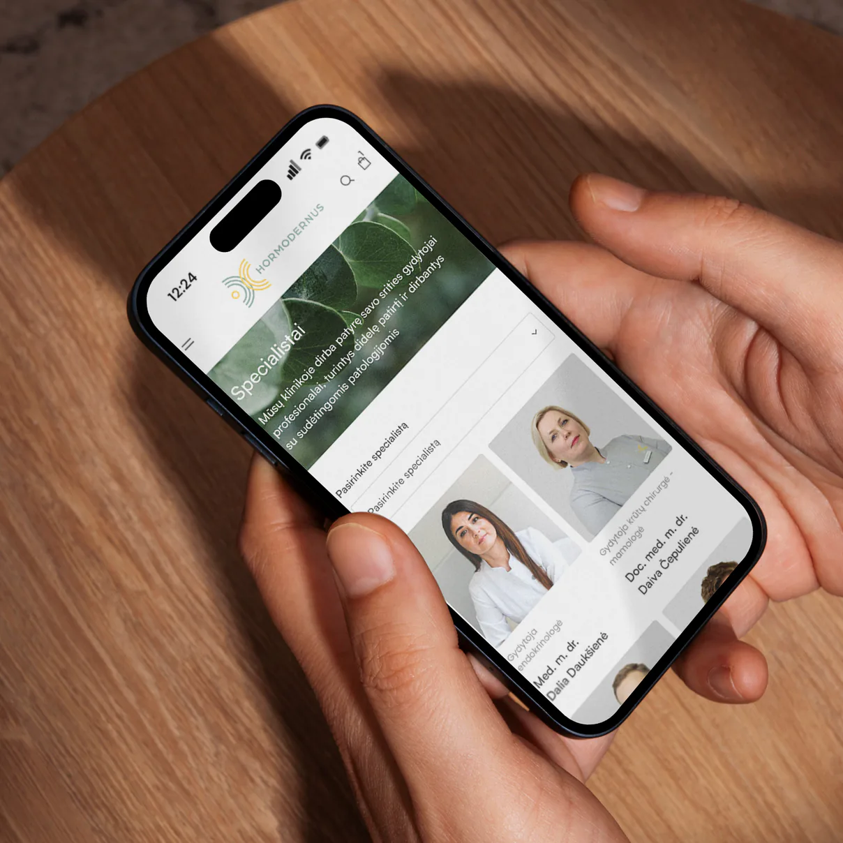 Hormodernus gydytojų specialistų sąrašas telefone, laikomame rankose